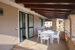 a patio with a table and chairs on a balcony at Cala Greca Case Vacanze in Capo Rizzuto