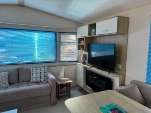 a living room with a couch and a flat screen tv at Captain's Cabin - Brixham - with designated parking in Brixham