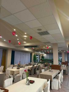a restaurant with white tables and white chairs and red balloons at Zajazd Przy Granicy in Słuczanka