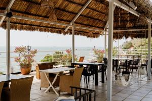 a restaurant with tables and chairs and a view of the ocean at Ananas Beach Hotel in Vung Tau