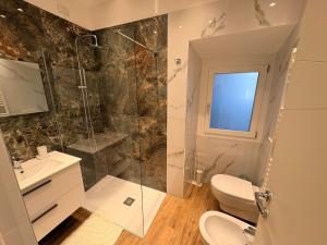 a bathroom with a shower and a toilet and a sink at Home Albert-Lago Maggiore Luino in Luino +38 photos