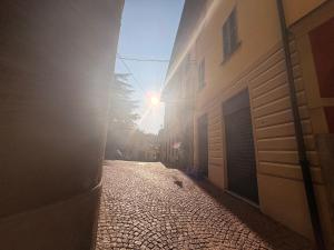 an alley way with the sun shining through a building at Home Albert-Lago Maggiore Luino in Luino