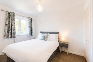 a bedroom with a bed and a window at Grantham Stays - Dexter - 3BR, Sleeps 5, Parking & WIFI in Grantham