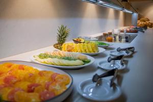 a buffet with plates of food on a counter at Hotel Marina in Roses +102 photos