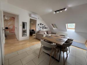 a dining room and living room with a table and chairs at Sunrise 2 Apartment in Hajdúszoboszló