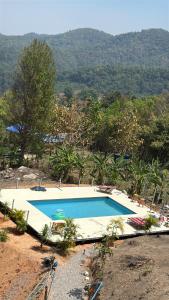a large swimming pool with a mountain in the background at Mountain springs resort in Ban Nong Khieo
