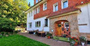 a white house with a red roof and a patio at Hotel Elisabeth Ilse in Braunlage
