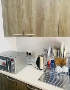 a microwave sitting on a kitchen counter with dishes at Stylish and spacious room in a quiet environment in Dawhwenya