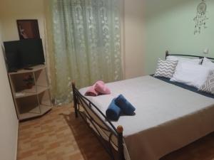 a bedroom with a bed with two pillows and a television at Aellia-Beautiful apartment in Vathi Samos in Vathý
