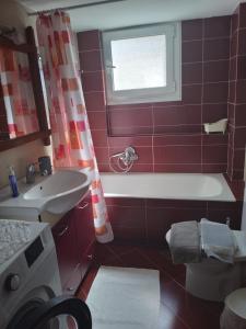 a bathroom with a tub and a sink and a window at Aellia-Beautiful apartment in Vathi Samos in Vathý