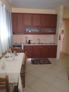 a kitchen with wooden cabinets and a table with a white table cloth at Aellia-Beautiful apartment in Vathi Samos in Vathý +12 photos