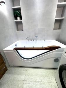 a white bath tub in a bathroom with a sink at Boulevard in Samarkand