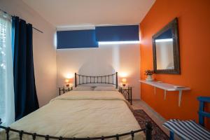 a bed in a room with orange walls and a mirror at Seafarer's Suite by Filos Inc in Galaxidi