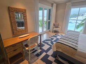 a bedroom with a desk and a bed with a window at Eden Island Gem in Eden Island