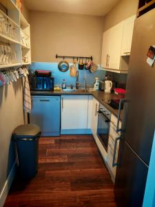 a small kitchen with white cabinets and blue appliances at Bedroom in Blanchardstown in Blanchardstown