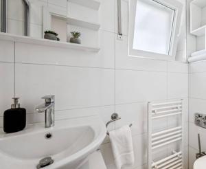 a white bathroom with a sink and a mirror at Prime Host Balcony Apartment in Karlsruhe +29 photos