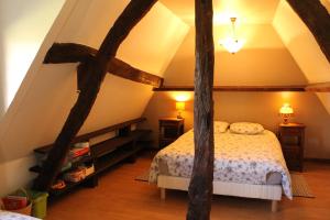 a bedroom with a bed in a attic at La Chaumière aux Faisans in Ablon