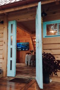 an open door of a wooden house with a table at Iglasta chata in Warszkowo