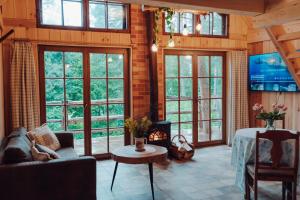 a living room with large windows and a fireplace at Iglasta chata in Warszkowo
