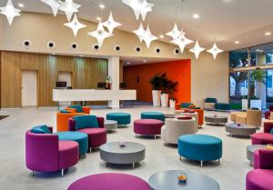 a lobby with colorful chairs and tables and stars at Barceló Corralejo Sands in Corralejo