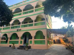a large building with green doors and windows at Sweet Mum in Malindi