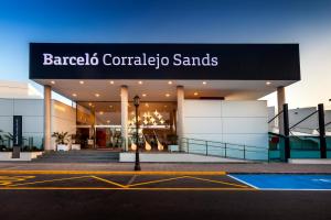 un bâtiment avec un panneau indiquant les sables barcelo coralejo dans l'établissement Barceló Corralejo Sands, à Corralejo