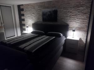 a bed in a room with a brick wall at Dreiländereck erkunden in Lörrach