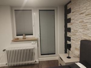 a living room with two windows and a stone wall at Dreiländereck erkunden in Lörrach