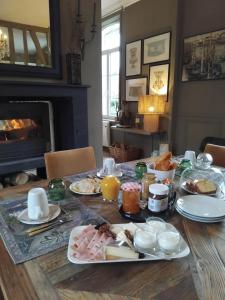 a dining room table with breakfast food on it at Laclos des champs in Vadencourt +24 photos