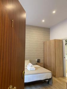 a bedroom with a bed and a wooden cabinet at Thor Hostal Boutique in Alicante