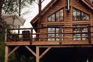 a tree house with a chair and an umbrella at Iglasta chata in Warszkowo