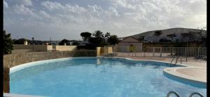 a large blue swimming pool with mountains in the background at CASA LUKASA 39c in Costa Calma