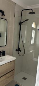 a shower in a bathroom with a sink and a mirror at CASA LUKASA 39c in Costa Calma +15 photos