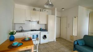 a kitchen and living room with white cabinets and a table at Monolocale DIRETTAMENTE SUL MARE cod 509 in Porto Recanati