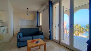 a living room with a blue couch and a balcony at Monolocale DIRETTAMENTE SUL MARE cod 509 in Porto Recanati +5 photos