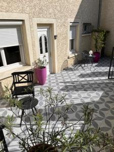 a patio with chairs and a table and a bench at Maison d'hôtes La Bella Casa in Villette-dʼAnthon