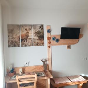 a room with a desk and a picture of a deer on the wall at Casa Noemi Imer in Imer