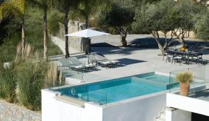 a swimming pool with a table and chairs and trees at Arbora Olea Luxury Villas in Skaleta