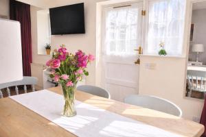 a vase of pink flowers sitting on a table at 10 Pudding Bag Lane in Exton