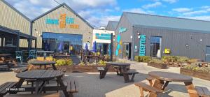 a group of picnic tables in front of a building at Heavenly Huts GC056 in Saint Osyth