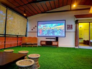 a large screen on a wall with chairs and a table at VILLA LEELA's WITH HOME THEATRE in Kodaikānāl