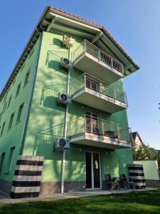 a green building with a dog on the balconies at Gästehaus Martha in Rust