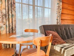 a living room with a table and a couch at Vējciems in Liepene