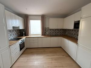 an empty kitchen with white cabinets and a window at Ferienhaus Halbritter Pouch 2 in Pouch +13 photos