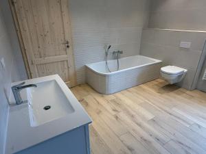 a bathroom with a tub and a toilet and a sink at Ferienhaus Halbritter Pouch 2 in Pouch
