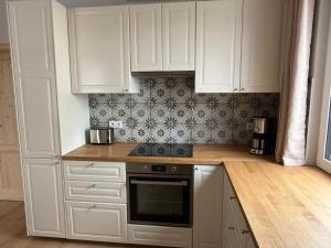 a kitchen with white cabinets and a stove top oven at Ferienhaus Halbritter Pouch 2 in Pouch