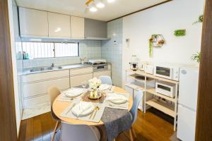 a kitchen with a table and chairs in a room at Casa Familia Aoshima in Miyazaki