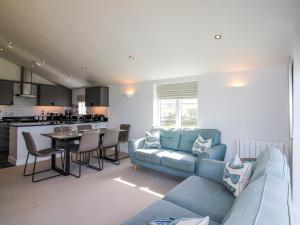 a living room with a blue couch and a kitchen at 7 Ocean's Edge in Kingsbridge