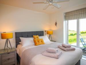 a bedroom with a large bed with two towels on it at 7 Ocean's Edge in Kingsbridge