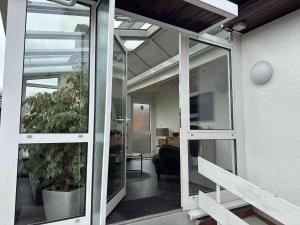 an open glass door to an office with a plant at Holiday home Max with fireplace in Thale-Friedrichsbrunn in Friedrichsbrunn